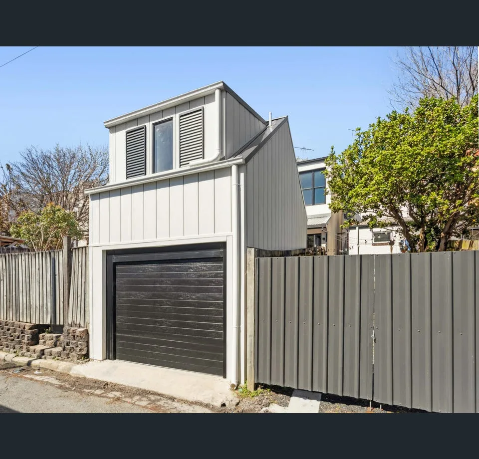 The rear of the property, seen from the laneway: a new two-storey structure with a garage below and a timber-clad studio with dormer windows above.