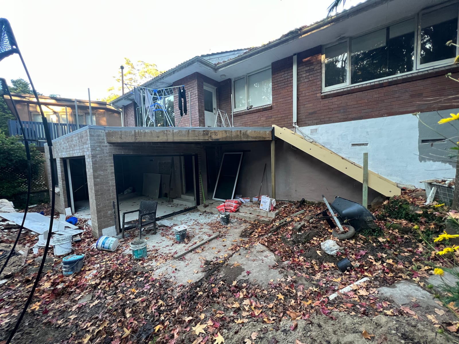The new lower-ground level nearing completion, with aluminium-framed windows and doors fitted and the new staircase above still under construction