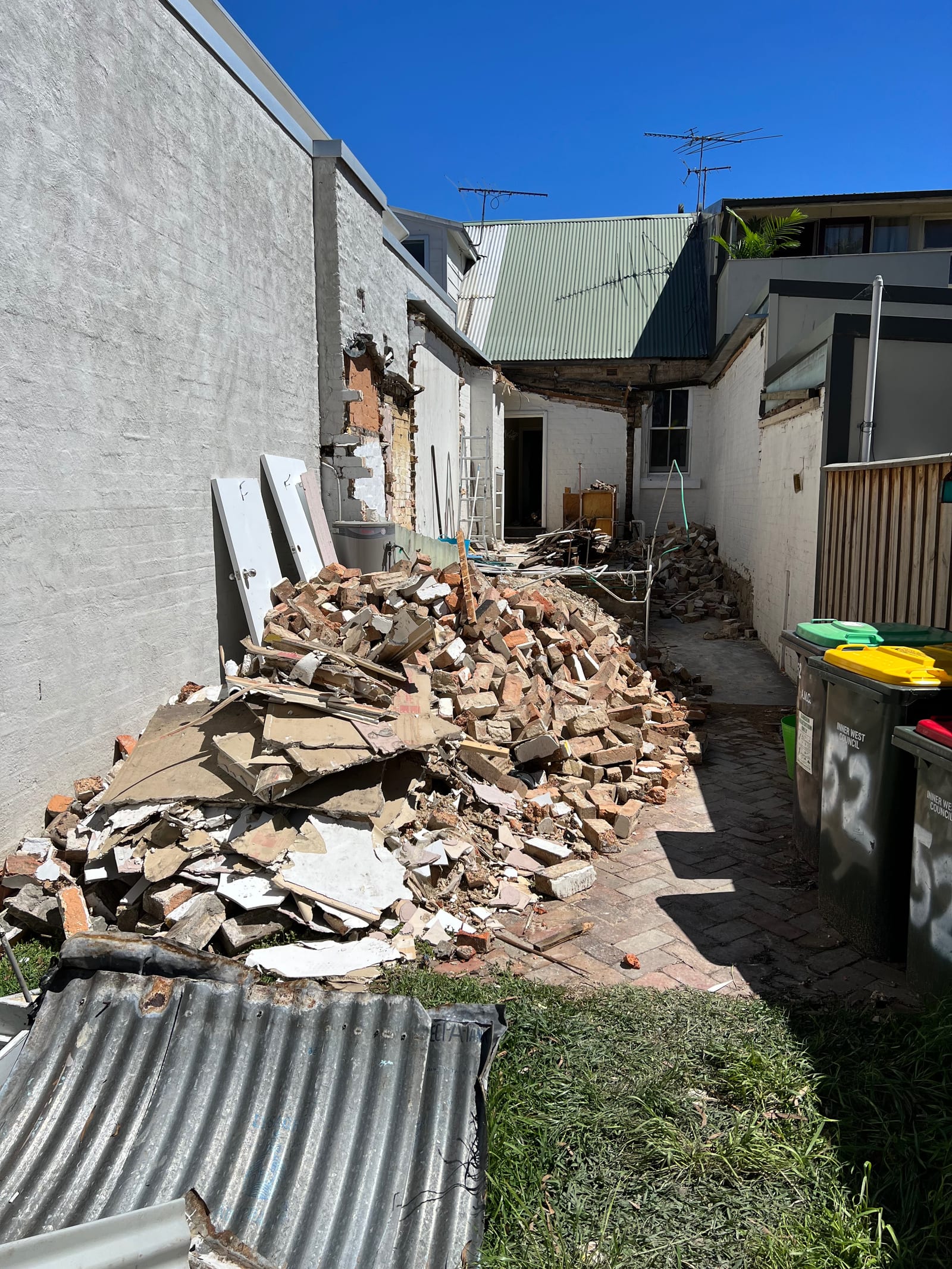 During construction — a demolished brick and rubble pile beside a partially removed original wall