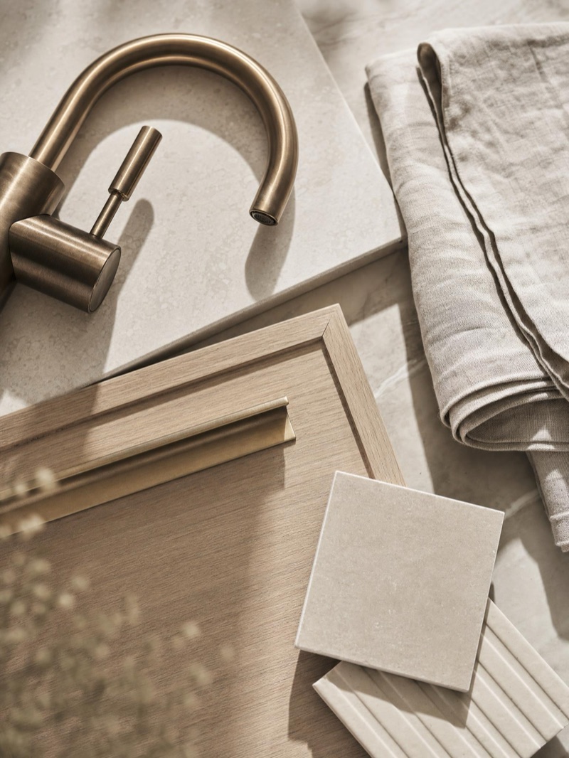 Laundry material selections — honed stone benchtop, timber-look joinery and brushed-brass tapware — illustrative concept